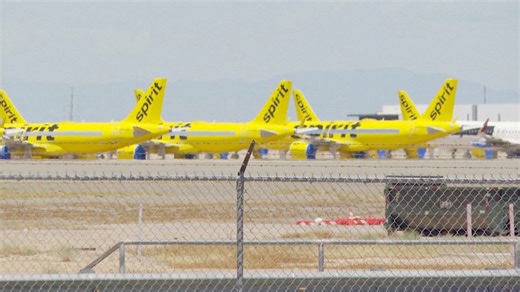 Dozens of Spirit airplanes parked on tarmac at Arizona airport