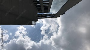 timelapse of clouds moving past a skyscraper, looking up the side of a sky scraper building. was filmed in Bangkok but the building is unidentifiable, could be anywhere.
