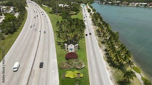 Aerial View of Welcome to Miami Beach Sign and Freeways Traffic, Revealing City Skyline in Background, Florida USA, Tilt Up Drone Shot