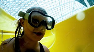 Teenage at water park coming down waterslide.