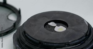 Close-up of a dentist applying a drop of yellow liquid to veneers. Veneer installation technology.