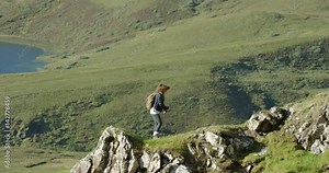 Woman dancing silly freestyle dance outdoors on cliff edge Crazy dancer girl having fun enjoying nature celebrating vacation travel adventure Scotland