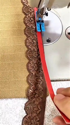 sewing brown lace onto a fabric using a professional machine to create a beautiful clothing detail