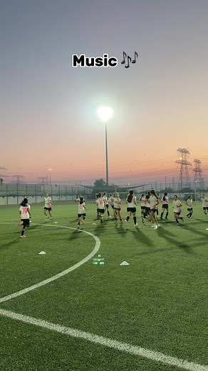 Young Female Soccer Players Training Under Evening Lights