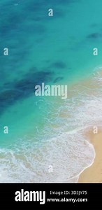Aerial view of clear turquoise ocean waves gently hitting a pristine tropical sandy beach. Conceptual background for travel, relaxation, promo, or summer advertisement Stock Video Footage - Alamy