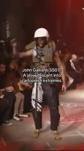 John Galliano Spring/Summer 2007 menswear was shown in Paris on June 30, 2006. The collection was framed around a Frankenstein reference, and the runway itself set the tone with gantries that sparked as the show began. The pacing is the point. It opens with sharply tailored looks, including shiny sharkskin suits and python-printed trenches, then shifts into a surf-bum group that is called out as a reminder of Galliano’s swimwear range. The final passage turns into character work, with a run of T