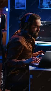 Developer typing code in home office, using Java programming language to develop software application. It professional using multimonitor PC setup and laptop to finish tasks, camera B