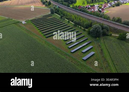 Drone captures sprawling Bavarian countryside with trains on railway tracks. Solar panels generate clean energy, blending eco transport, renewable electricity, and agriculture in Germany rural fields Stock Video Footage - Alamy