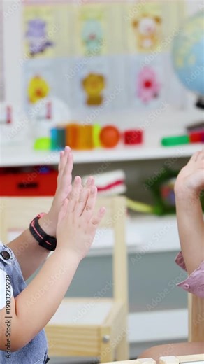 Two Young Asian Girls Playing Hand Clapping Games in Kindergarten Classroom
