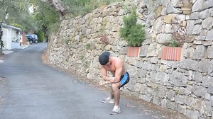 Homme torse nu musclé échauffant dans la rue