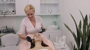 RF lifting, Gel application, Pre-treatment steps. Cosmetologist applies conductive gel to client using knuckle prior to RF lifting procedure.