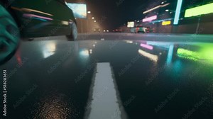 Reflection of car headlights and neon lights on wet pavement in the night city.