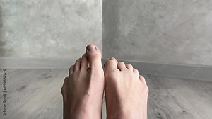 Bare feet showcase flexibility and anatomy, moving toes in various positions on a hardwood floor. Perfect for health and wellness content