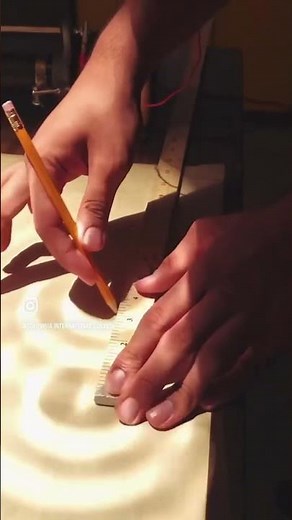 Grade 12 Physics students observing interference patterns of water waves in the ripple tank