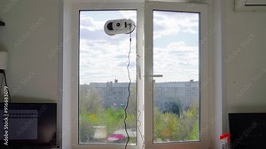 Window cleaning robot at work. Glass cleaning with technology and modern gadget. Robot washes window at home.