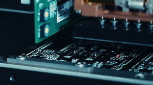 Close-up Macro Shot of Electronic Printed Circuit Board Being Assembled with Automated Robotic Arm, Surface Mounted Technology Connecting Microchips, Transistors, Capacitors to the Motherboard
