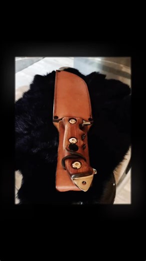 So this is my 2nd Tracker/Bowie survival knife, this time I made a sheath for the first time out of the thickest vegetable tanned cowhide they had at Tandy Leather that I drilled and saddle-stitched with waxed thread, it's dyed with mahogany brown and plain black on the edges with matte black rivets and snap and the only thing different about the knife is it's so fuckin' heavy I wanted a super positive grip for it so there's a couple of extra finger grips and I found this really dense GORGEOUS w