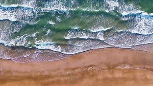 Ocean waves on the beach as a background. Aerial top down view of beach and sea with blue water waves. Vietnam beach