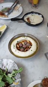 Middle Eastern dish, hummus, tahini, chickpeas, creamy dip, roasted almonds, olive oil, food photography, traditional dish, Arabic cuisine, gourmet food, Levantine food, delicious appetizer.