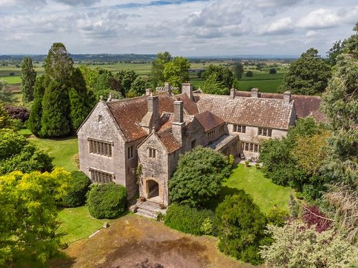 A converted medieval monastery set in 16 acres of Somerset that has a miniature castle as its poolhouse