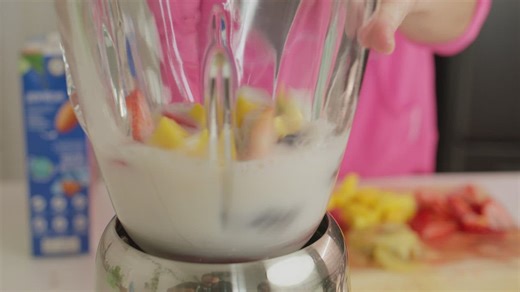 Mixing fruit and milk in a blender - Free Stock Video