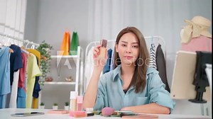 Young Asia woman workin online e-commerce shopping at home. Startup online fashion cloth business. Set up live streaming by using tablet video call show product to customer. Buy and sell concept