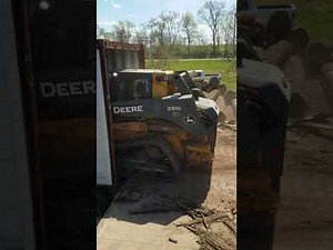 The Beak Skid Steer Attachment - loading logs into shipping container