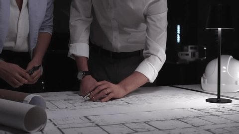 clip-3998840721-architects-engineers-collaborating-on-blueprint-plans-working