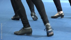 People dancing together tap dance at musical festival. Tappers striking on blue floor. Close up of tap shoes, shiny light on carpet background. Vintage dance style, leisure and musical culture