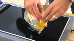 Chef Cooks Eggs, Bacon and Chocolate in a Pan Cut in Half to Demonstrate How Induction Cooking Works
