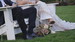 Bride and groom relax in beach chairs with their drinks