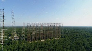 Aerial view of the DUGA radar station near the city of Chernobyl-2 among the forest. Exclusion Zone. Camera moves back. 4K drone footage.