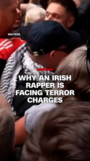 Hundreds of supporters turned out in central London to support an Irish rapper facing terror charges. Mo Chara, from the Irish language rap group Kneecap, is accused by British authorities of displaying a flag supporting Hezbollah, a designated terror group in the UK. CNN's Niamh Kennedy reports. https://cnn.it/4mna18n | CNN