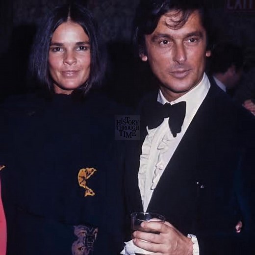 "On a crisp evening in New York City in 1971, Ali MacGraw and Robert Evans were photographed arm in arm at the National Association of Theater Owners Awards ceremony, their presence a portrait of early-'70s Hollywood power and glamour. Captured by the legendary paparazzo Ron Galella, the couple radiated elegance—Ali in a flowing satin gown, her signature dark hair parted center, and Evans in a sharply tailored tuxedo with tinted glasses, embodying the confident bravado of a studio mogul. Their m