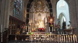 Ornate altar inside Cathedral of Our Lady in Antwerp with flowers, candles and spiritual atmosphere