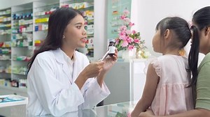 Beautiful asian Pharmacist explaining the medication to patient in drug store