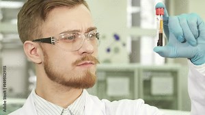 Focused lab technician examining a test tube with assays