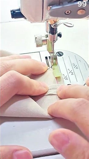 Hands guide fabric edges through sewing machine