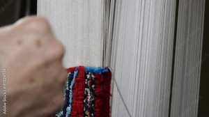 carpet making. manual manufacturing of oriental carpets. close-up video of carpet weaving