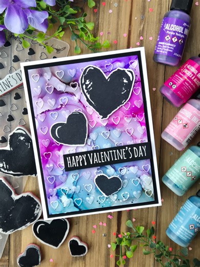Sending all the love with this vibrant alcohol ink Valentine’s card by @luv2papercraft 💕 Those bold hearts and dreamy blends are giving all the romantic vibes. Created with @tim_holtz Alcohol Ink for a background that’s perfectly unpredictable and full of movement. Supplies: Tim Holtz Alcohol: -Inks® Fiesta, Cosmopolitan, Bayou, Juniper, Smudge, Mushroom -Yupo Cardstock -Ink Blower Tim Holtz Distress: -Paint: Black Soot, Picket Fence -Black Heavy Stock -Watercolor Paper -Sanding Disks Ranger: -