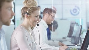4K Portrait smiling customer service operator taking calls in busy call center Dec 2016-UK