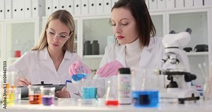 Female scientists work with chemical reagents in modern lab
