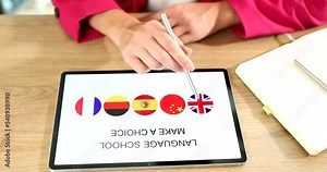 Woman hand uses tablet with her fingers and an app is popular free platform for learning languages