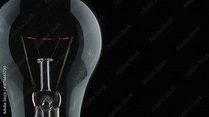 dramatic burnout of a filament inside an incandescent light bulb, with a sudden flash and smoke as the filament breaks. Captures the intensity and fragility of electric light.