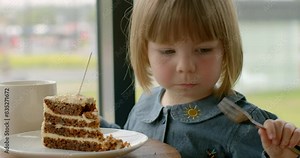 Babies. Little girl eating with a fork in left hand, left-handedness. Unique characteristics of a left-handed child, showcasing concentration and skill as baby enjoys her meal.