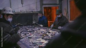 Trash sorting. Conveyor for waste. Recycling garbage. Men sort metal garbage on a conveyor. Recycle process, secondary use of plastic. Recycling factory. Male workers recycle scrap metal. Littering