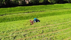 Hay tedder in action filmed from above during hay harvest | Premium Stock Video Footage