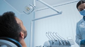 Dentist using dental instruments while working with patient in clinic