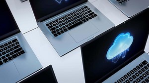 Several laptops with cloud computing icons on them