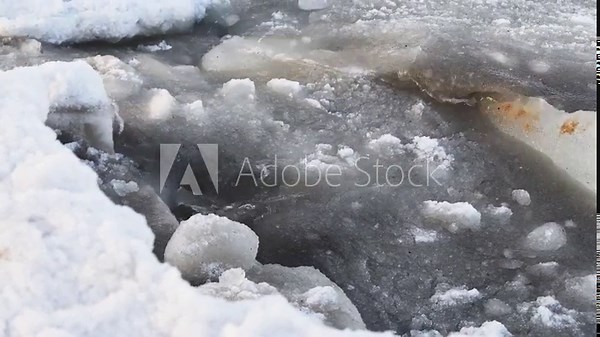 Close-up of winter sea slush ice melting with rough icy textures and cold gray tones